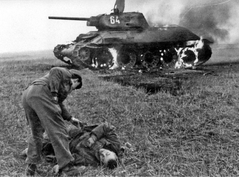 Немецкий солдат обыскивает погибшего советского солдата-пехотинца. вов, фото
