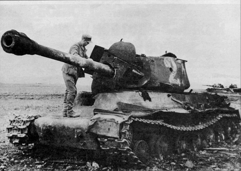 Немецкий солдат осматривает уничтоженный взрывом боекомплекта в результате пробития лобовой брони над люком механика-водителя советский танк ИС-2. На дальнем плане видны еще два подбитых ИСа. вов, фото