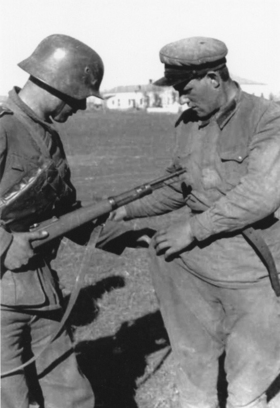 Немецкий солдат проверяет карманы сдавшегося в плен красноармейца. вов, фото