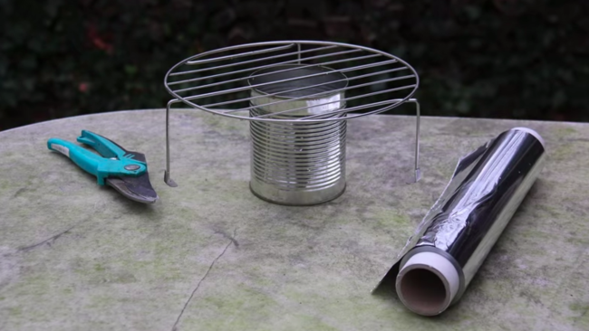 What you'll need to make your own DIY BBQ grill: A tin can, garden shears, aluminum foil, a cheap rack, and some charcoal.