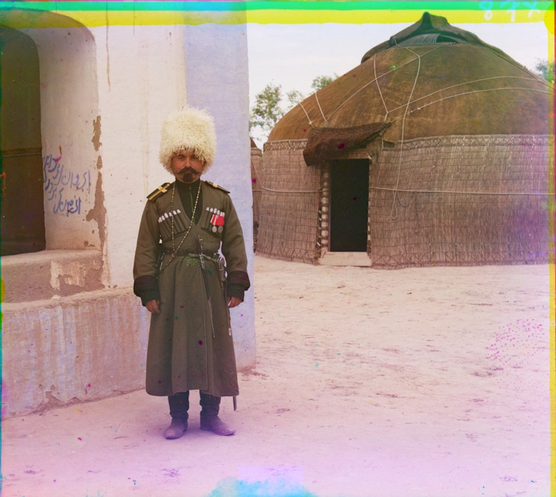 Man in uniform beside building, yurt in background. (between 1905 and 1915)