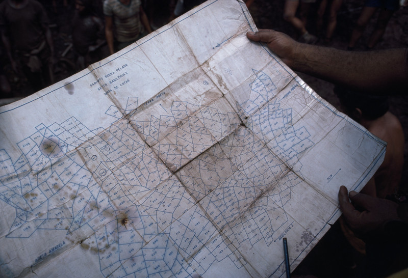 Mine surveyors consult a map of plots in the mine.