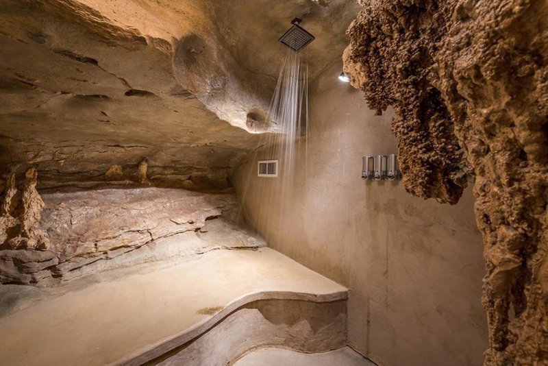 Surrounding rock walls and overhead rain showers offer a waterfall-like experience