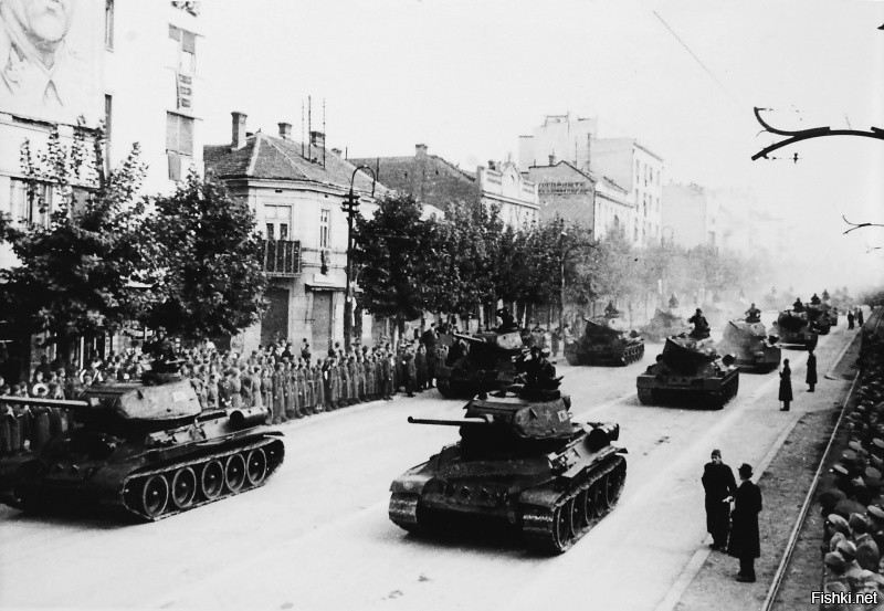 Танки Т-34-85 НОАЮ идут на параде в честь годовщины освобождения Белграда от немецких войск. Танки проходят по Бульвару короля Александра. На стене здания слева портрет маршала Югославии Иосипа Броз-Тито.