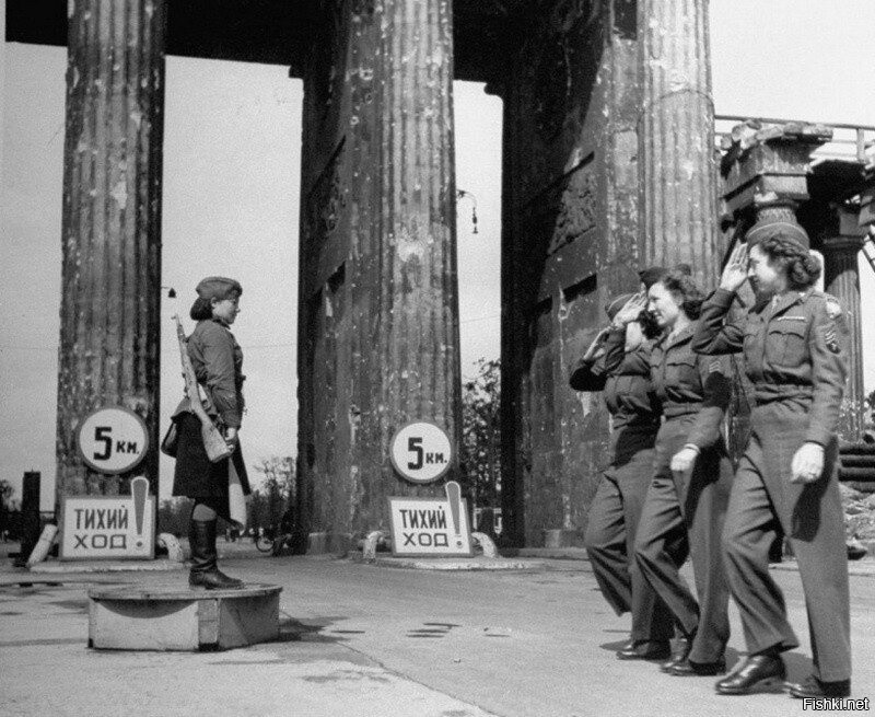 Американские девушки-военнослужащие отдают воинское приветствие советской регулировщице в Берлине у Бранденбургских ворот